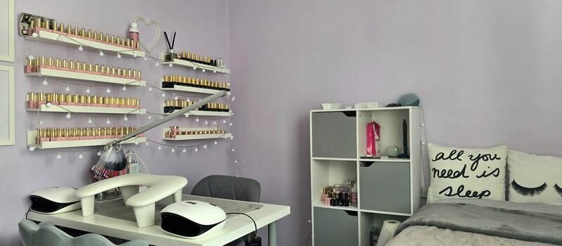 The studio: nail desk, colour shelves and lash bed